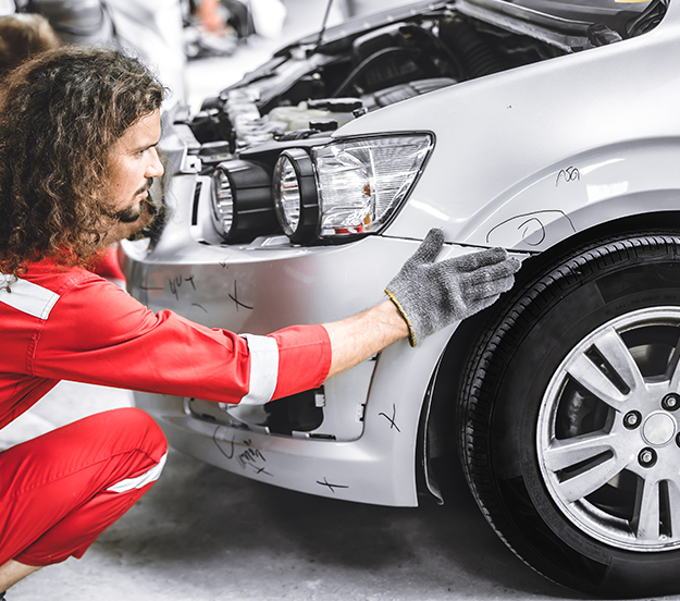 Technician inspecting car bodywork damage